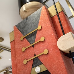 Orion fabricates 2 giant crystal encrusted toy soldiers that flank the cash wrap, alongside sparkling signage and red velvet drapes embellished with Crystals from Swarovski